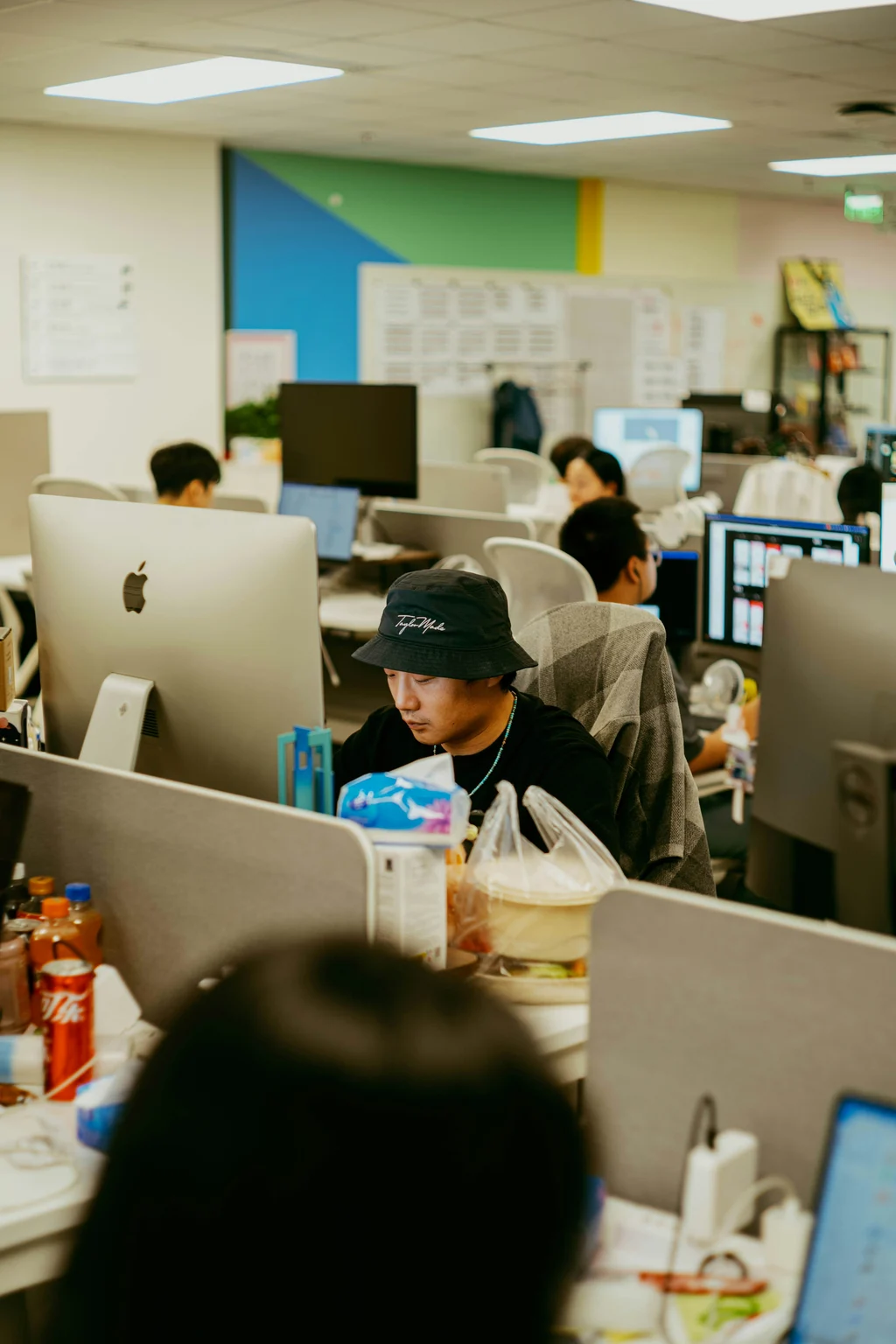 Employees working at computers in an open office as AI job losses reshape career planning