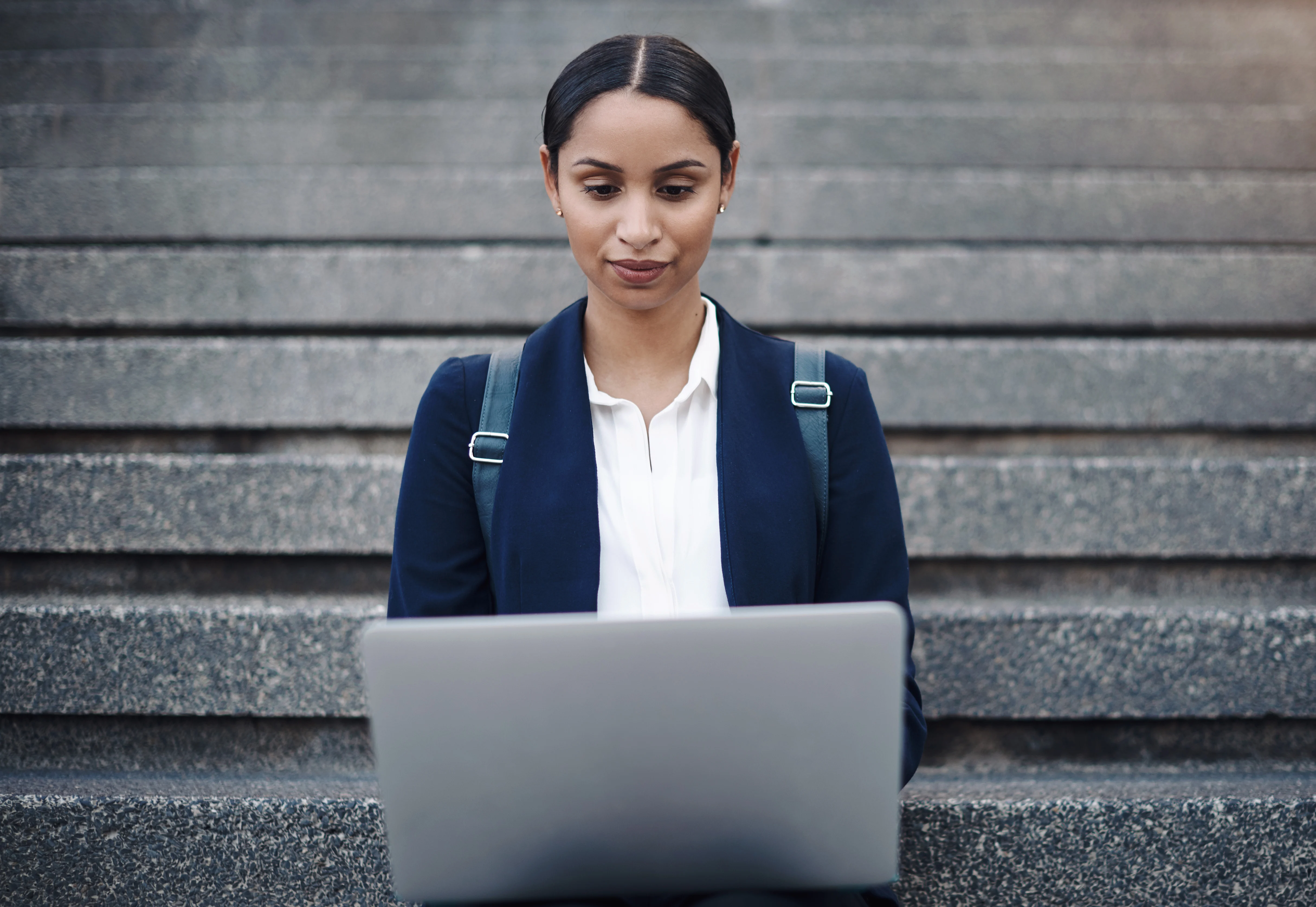 Professional woman using a laptop while researching barriers to changing careers